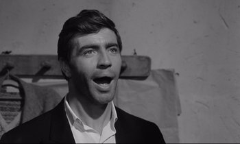 Movie still from “Zorba the Greek” (1964), directed by Michael Cacoyannis – A black and white photo of a man with a surprised look on his face; Close Up shot, Low angle
