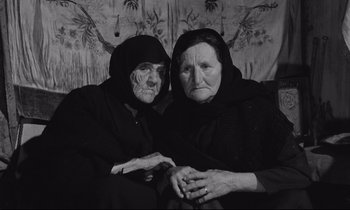Movie still from “Zorba the Greek” (1964), directed by Michael Cacoyannis – Two older women sitting next to each other; Medium shot, High angle