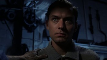 Movie still from “eXistenZ” (1999), directed by David Cronenberg – A person with a hand on his chest; Close Up shot, Low angle