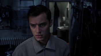 Movie still from “eXistenZ” (1999), directed by David Cronenberg – A young man in a gray jacket looking at the camera; Close Up shot, Low angle