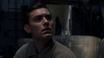 Movie still from “eXistenZ” (1999), directed by David Cronenberg – A man looking up at the sky in a dark room; Close Up shot, Low angle