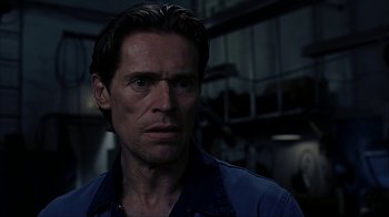 Movie still from “eXistenZ” (1999), directed by David Cronenberg – A person wearing a blue shirt; Close Up shot, Over the shoulder angle
