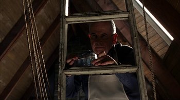 Movie still from “eXistenZ” (1999), directed by David Cronenberg – A man is looking through a window frame; Medium shot, Low angle