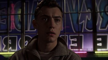 Movie still from “eXistenZ” (1999), directed by David Cronenberg – A young man is looking into the camera; Close Up shot, Low angle