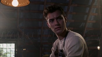 Movie still from “eXistenZ” (1999), directed by David Cronenberg – A man with a camera in a room with lights; Close Up shot, Low angle