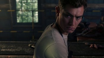 Movie still from “eXistenZ” (1999), directed by David Cronenberg – A person wearing a white shirt; Close Up shot, Low angle