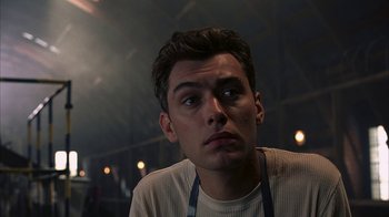 Movie still from “eXistenZ” (1999), directed by David Cronenberg – A person wearing a white shirt; Close Up shot, Low angle