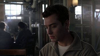 Movie still from “eXistenZ” (1999), directed by David Cronenberg – A man sitting in a room with his eyes closed; Close Up shot, Over the shoulder angle