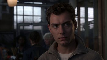 Movie still from “eXistenZ” (1999), directed by David Cronenberg – A person wearing a jacket; Close Up shot, Over the shoulder angle