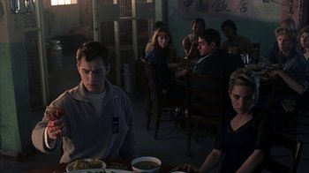 Movie still from “eXistenZ” (1999), directed by David Cronenberg – A group of people sitting at a table eating food; Medium shot, Over the shoulder angle