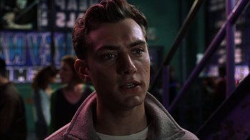 Movie still from “eXistenZ” (1999), directed by David Cronenberg – A young man is looking into the camera; Close Up shot, Over the shoulder angle