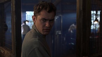 Movie still from “eXistenZ” (1999), directed by David Cronenberg – A man with a serious look on his face; Close Up shot, Over the shoulder angle