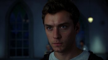 Movie still from “eXistenZ” (1999), directed by David Cronenberg – A man's face in a dark room; Close Up shot, Low angle