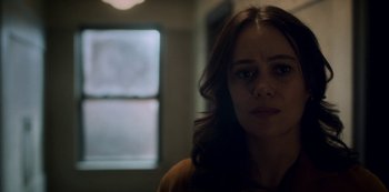 Movie still from “Archive 81” (2022), created by Rebecca Sonnenshine – A young woman is staring at the camera; Close Up shot, Over the shoulder angle