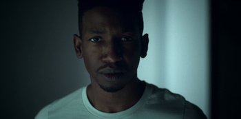 Movie still from “Archive 81” (2022), created by Rebecca Sonnenshine – A person wearing a white t - shirt; Close Up shot, Low angle