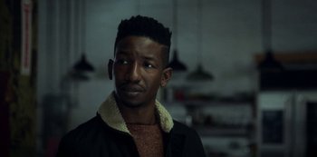 Movie still from “Archive 81” (2022), created by Rebecca Sonnenshine – A man in a black jacket is looking to his left; Close Up shot, Over the shoulder angle