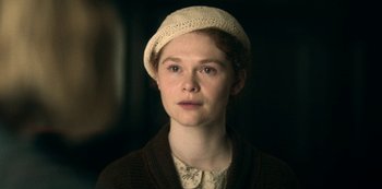 Movie still from “Archive 81” (2022), created by Rebecca Sonnenshine – A young woman wearing a white hat in a dark room; Close Up shot, Over the shoulder angle