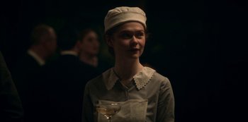 Movie still from “Archive 81” (2022), created by Rebecca Sonnenshine – A woman wearing a white hat and holding a glass; Medium shot, Over the shoulder angle