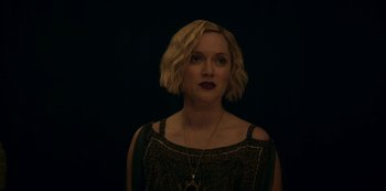 Movie still from “Archive 81” (2022), created by Rebecca Sonnenshine – A woman with short blonde hair wearing a black top; Close Up shot, Low angle