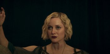 Movie still from “Archive 81” (2022), created by Rebecca Sonnenshine – A person with short blonde hair; Close Up shot, Over the shoulder angle