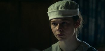 Movie still from “Archive 81” (2022), created by Rebecca Sonnenshine – A woman wearing a white hat looking at the camera; Close Up shot, Low angle