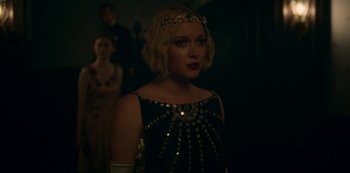Movie still from “Archive 81” (2022), created by Rebecca Sonnenshine – A woman in a black and gold dress with a tiara; Close Up shot, Over the shoulder angle