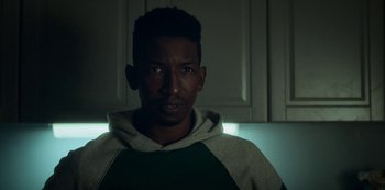 Movie still from “Archive 81” (2022), created by Rebecca Sonnenshine – A person wearing a hoodie; Close Up shot, Over the shoulder angle