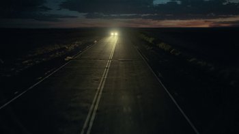 Movie still from “Army of the Dead” (2021), directed by Zack Snyder – The headlights of a car on a road at night; Extreme Wide shot, High angle