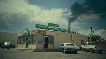 Movie still from “Army of the Dead” (2021), directed by Zack Snyder – A car parked in front of a building with smoke billowing from it; Extreme Wide shot, Low angle