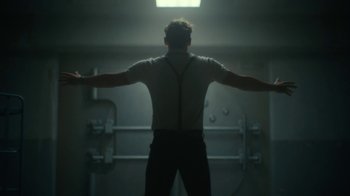 Movie still from “Army of the Dead” (2021), directed by Zack Snyder – A man standing in the middle of a room with his arms outstretched; Medium shot, Low angle