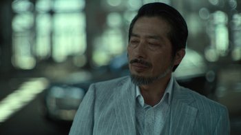 Movie still from “Army of the Dead” (2021), directed by Zack Snyder – A person wearing a suit and tie; Close Up shot, Low angle