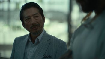 Movie still from “Army of the Dead” (2021), directed by Zack Snyder – A person wearing a suit and tie; Close Up shot, Over the shoulder angle