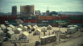 Movie still from “Army of the Dead” (2021), directed by Zack Snyder – A group of people walking in a field with tents; Extreme Wide shot, High angle