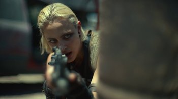 Movie still from “Army of the Dead” (2021), directed by Zack Snyder – A woman is holding a gun and aiming at something; Close Up shot, Over the shoulder angle