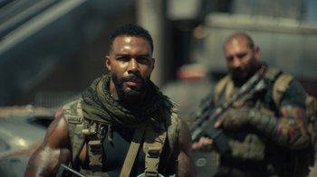 Movie still from “Army of the Dead” (2021), directed by Zack Snyder – A man with a beard is holding a gun; Close Up shot, Over the shoulder angle