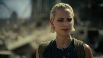 Movie still from “Army of the Dead” (2021), directed by Zack Snyder – A woman with blonde hair wearing a black shirt; Close Up shot, Over the shoulder angle