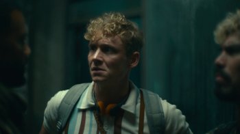 Movie still from “Army of the Dead” (2021), directed by Zack Snyder – A person with curly blonde hair; Close Up shot, Low angle