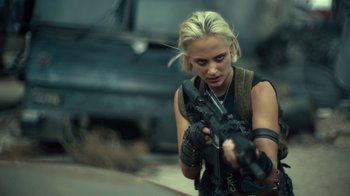 Movie still from “Army of the Dead” (2021), directed by Zack Snyder – A woman holding a gun while standing next to a car; Medium shot, Over the shoulder angle