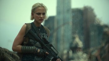 Movie still from “Army of the Dead” (2021), directed by Zack Snyder – A woman holding a gun while standing in front of a building; Medium shot, Over the shoulder angle