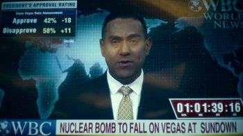 Movie still from “Army of the Dead” (2021), directed by Zack Snyder – A man in a suit and tie on a television screen; Close Up shot, Over the shoulder angle