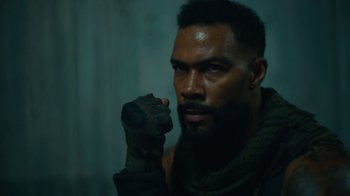 Movie still from “Army of the Dead” (2021), directed by Zack Snyder – A black man with a beard and gloves on; Close Up shot, Low angle