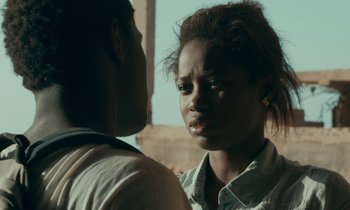 Movie still from “Atlantics” (2019), directed by Mati Diop – A man and a woman standing next to each other; Close Up shot, Over the shoulder angle