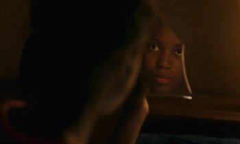 Movie still from “Atlantics” (2019), directed by Mati Diop – A woman looking at herself in a mirror; Close Up shot, Over the shoulder angle