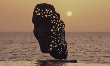 Movie still from “Atlantics” (2019), directed by Mati Diop – A sculpture of an animal on top of the water; Extreme Wide shot, Low angle