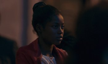Movie still from “Atlantics” (2019), directed by Mati Diop – A young black woman looking at the camera; Close Up shot, Over the shoulder angle