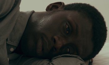 Movie still from “Atlantics” (2019), directed by Mati Diop – A person laying on the ground; Extreme Close Up shot, Overhead angle