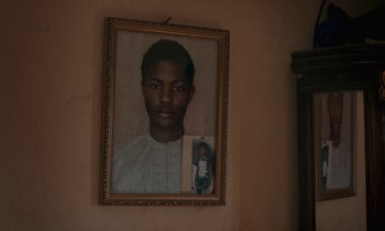 Movie still from “Atlantics” (2019), directed by Mati Diop – A portrait of a young man with a picture of a young boy; Close Up shot, Overhead angle