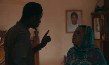 Movie still from “Atlantics” (2019), directed by Mati Diop – A man and a woman talking in a living room; Medium shot, Over the shoulder angle