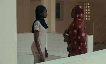 Movie still from “Atlantics” (2019), directed by Mati Diop – Two women are standing in a bathroom talking; Medium shot, Over the shoulder angle