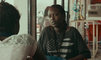 Movie still from “Atlantics” (2019), directed by Mati Diop – A woman sitting in front of a window; Close Up shot, Over the shoulder angle
